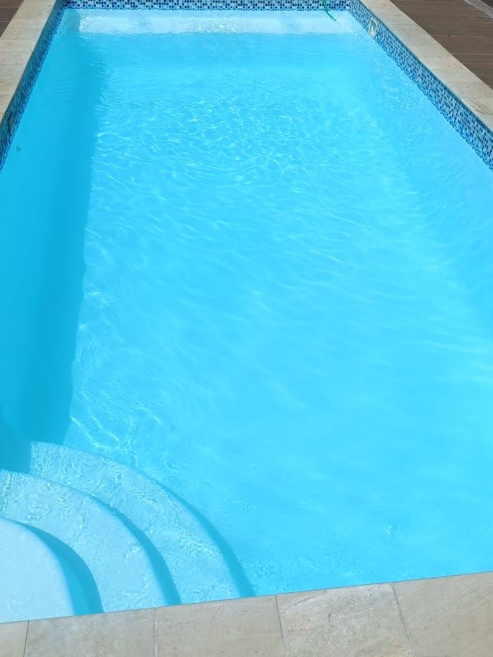 Piscina com borda de pedra e água azul depois da limpeza, Sertanópolis e região